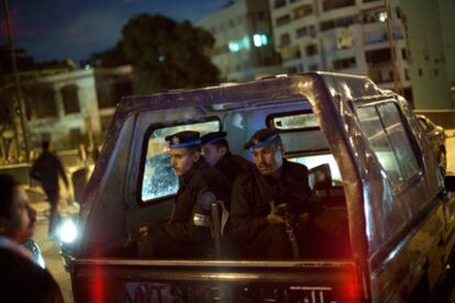 Un vehículo que traslada a policías egipcios es detenido en un puesto de control establecido por vecinos de un barrio de El Cairo, en uno de los extremos de un puente sobre El Nilo.