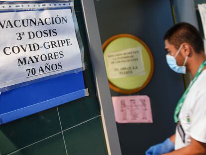 Un enfermero entra en una sala donde se administran vacunas contra la gripe y terceras dosis de la vacuna contra la covid-19 en un centro sanitario de Valencia.