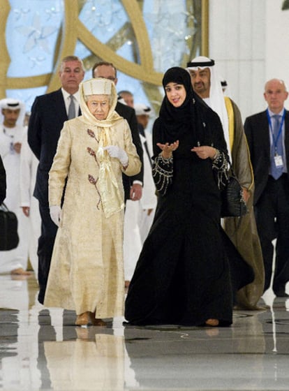 Isabel II ha adaptado su vestuario a las normas de los Emiratos Árabes Unidos, que visita esta semana. Vistiendo un traje largo con abrigo a juego en tonos claros y con un sombrero y encima un largo velo, la reina acudió a la mezquita Gran Sheij Zyaed acompañada de la ministra de Estado. Para cumplir también con lo establecido, Isabel II se descalzó como todo el mundo. Detrás de ella camina su hijo Andrés, que la acompaña en este viaje, además de su marido, Felipe de Edimburgo.