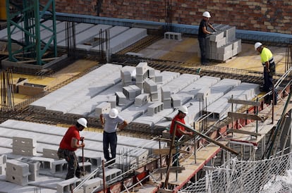 Trabajadores de la construcción levantan un edificio en Bilbao.