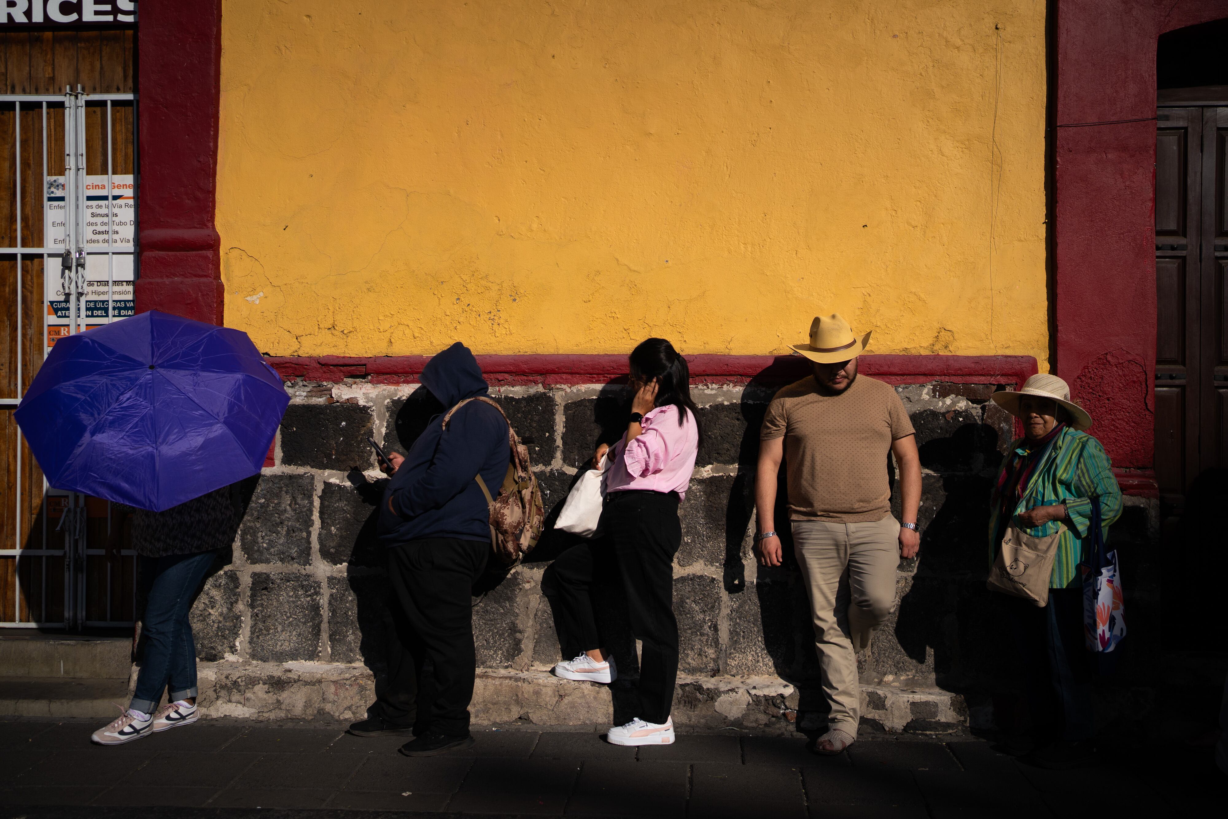 Ciudadanos esperan bajo el sol para poder votar en una casilla especial en Xochimilco, este domingo.