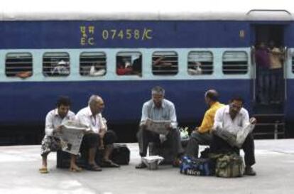 Varios pasajeros leen la prensa para matar el tiempo mientras esperan a que se restablezca hoy el servicio ferroviario en la estación de Amritsar, en el estado de Punjab (India).