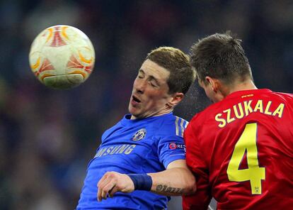 Fernando Torres disputa un balón con Lukasz Szukala.