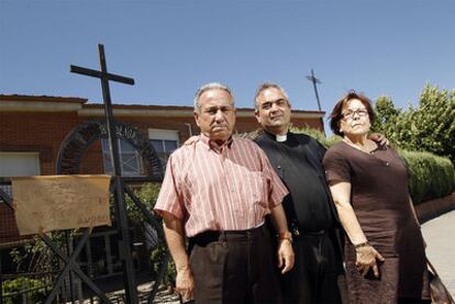 El sacerdote Andrés García Torres posa con sus padres a la entrada de la parroquia.