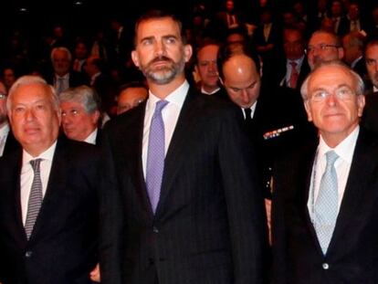 El príncipe Felipe (en el centro) con el ministro de Exteriores, José manuel Margallo y el presidente de Caixabank, Isidro Fainé.