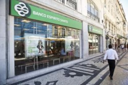 Un hombre camina junto a una sucursal del Banco Espirito Santo en Lisboa. 