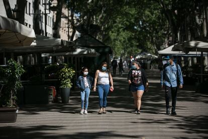 Una familia pasea por La Rambla de Barcelona.