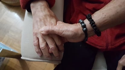 Una mujer coge la mano de su marido, con Alzhéimer.