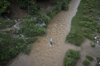 Un hombre cruza por el Río Massacre para llegar de Dajabón, República Dominicana.