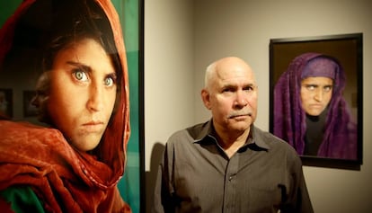 Steve McCurry posa junto a las fotos de Sharbat Gula en una exposición en Hamburgo en 2013.