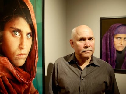 Steve McCurry posa ao lado das fotos de Sharbat Gula em uma exposição em Hamburgo em 2013.