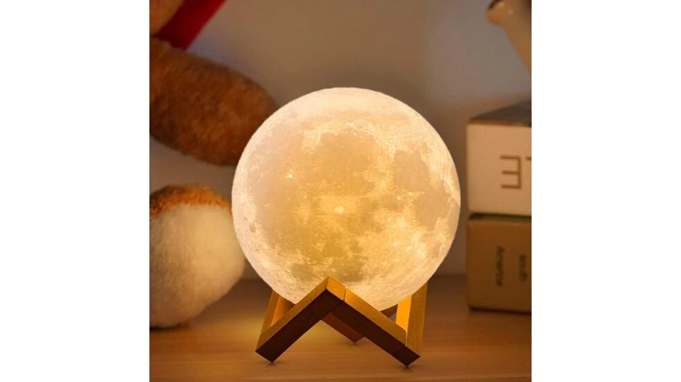 Esta lámpara de luna incorpora un soporte de madera.