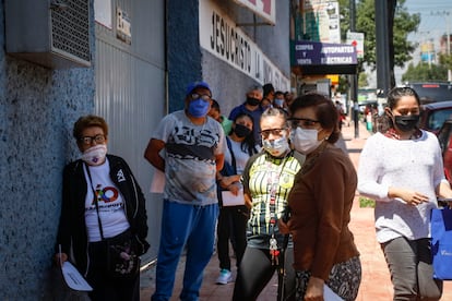 Vecinos en la Alcaldía Álvaro Obregón se forman para recibir vales de despensa del Gobierno de Ciudad de México.