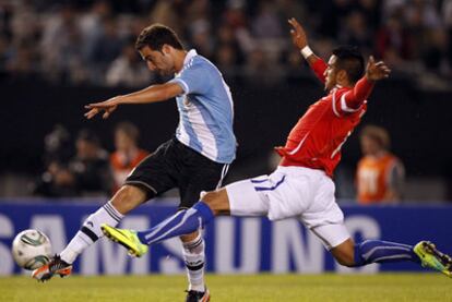 Higuaín ejecuta su característico golpeo con el empeine ante la oposición del chileno Vidal.