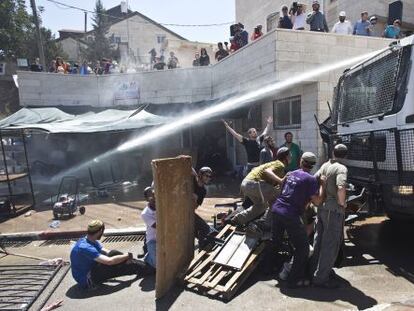 Agentes israel&iacute;es lanzan agua contra colonos del asentamiento de Beit EI, el mi&eacute;rcoles.