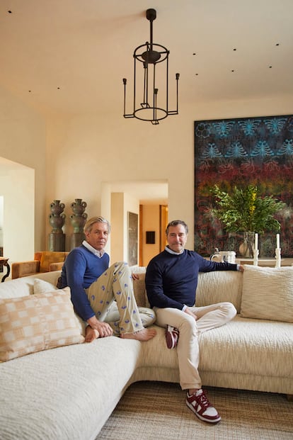 Michael S. Smith y James Costos posan para El País Semanal en uno de los salones de su casa, ubicada en el barrio de Holmby Hills, al oeste de Los Ángeles. En la imagen, detrás de la pareja, un par de esculturas de Peter Schlesinger, y Choir, 2014-2015, obra del artista estadounidense Philip Taaffe. 