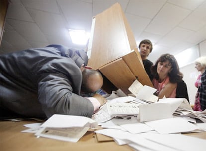 Un encargado del recuento electoral en un colegio de Chisinau se asegura de que no queda ningún voto en la caja.