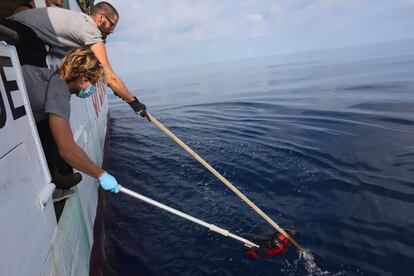 Momento en el que los rescatistas del buque 'Open Arms' recuperan la mochila roja de aproximadamente 70 litros que llevaba semanas flotando en el Mediterráneo.

