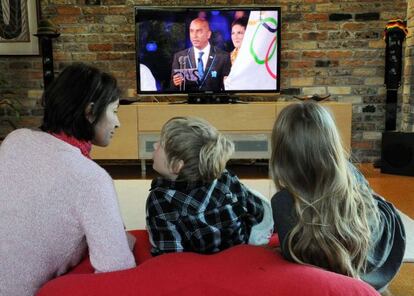 Una familia ve los Juegos Olímpicos por televisión.