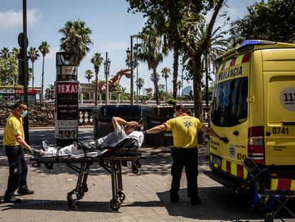 Dos sanitarios subían a un paciente a una ambulancia durante la ola de calor, en Barcelona, el lunes.