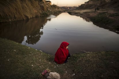 Una muchacha se sienta en el borde de un arroyo en un barrio pobre en las afueras de Islamabad (Pakistán).