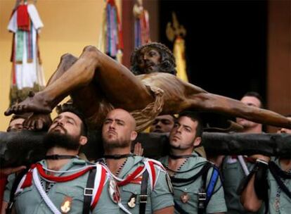 Legionarios llevan en procesión al Cristo de la Buena Muerte en Málaga.