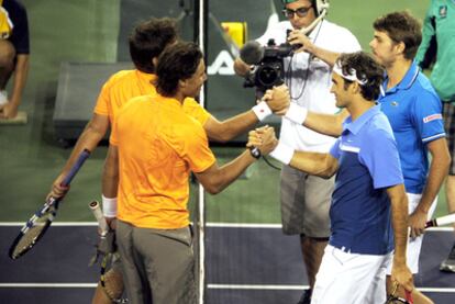 Nadal y Federer se saludan tras su enfrentamiento de dobles.