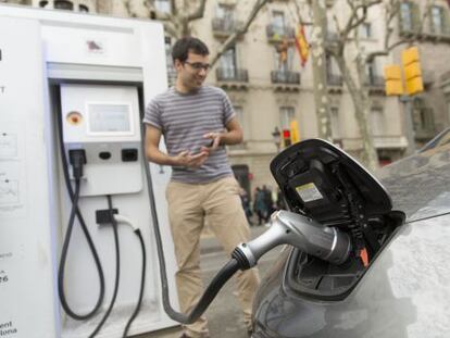 Un conductor endolla el seu cotxe elèctric en un punt de recarrega ràpida situat al passeig de Gràcia.