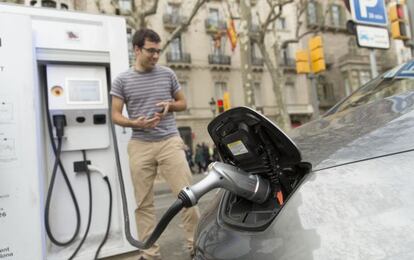 Un conductor enchufa su coche el&eacute;ctrico en un punto de recarga r&aacute;pida ubicado en el paseo de Gr&agrave;cia.