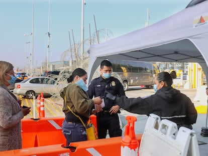 Una mujer muestra su cartilla de vacunación a autoridades estadounidenses en un paso fronterizo en Tijuana, en noviembre de 2021.