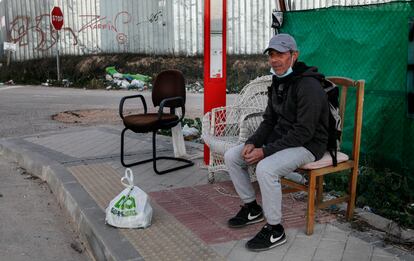 Dimas Sánchez espera el autobús en una de las sillas recicladas.