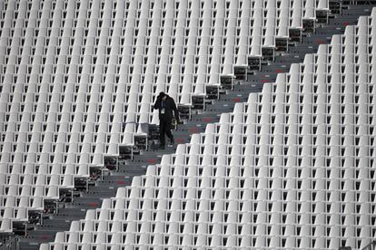 Un trabajador camina por las gradas vacías de la zona de meta por donde transcurrirán las pruebas de esquí alpino antes de los Juegos Olímpicos de invierno de Sochi 2014 