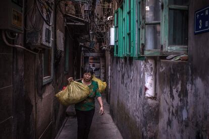 Una mujer camina por una calle de Xianmen (China) cargada bolsas. Xianmen fue una de las primeras ciudades chinas en adherirse a la Zona Económica Especial en los años 70 para impulsar la economía y las empresas chinas al mundo exterior.