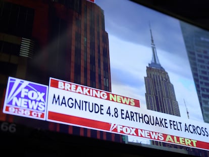 A screen at the New York Stock Exchange shows a news alert of a magnitude 4.8 earthquake in New York City.