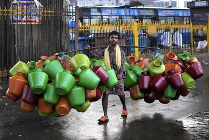 Un hombre transporta jarras de agua vacías para venderlas en el mercado de la ciudad india de Bangalore.