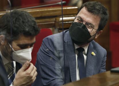 El presidente de la Generalitat, Pere Aragonés (d), acompañado por el vicepresidente, Jordi Puigneró (i), durante el pleno del Parlament