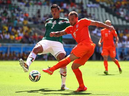 Wesley Sneijder y Francisco Javier Rodriguez compiten por el balón.