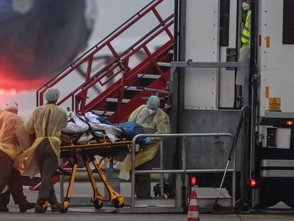 Sanitarios trasladan a un paciente con coronavirus a otra unidad de cuidados intensivos de Alemania, en un avión militar, este viernes en Memmingen (Baviera).