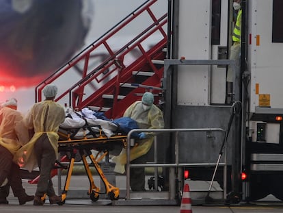 Sanitarios trasladan a un paciente con coronavirus a otra unidad de cuidados intensivos de Alemania, en un avión militar, este viernes en Memmingen (Baviera).