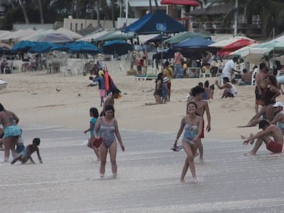 Turistas disfrutan de la playa. 