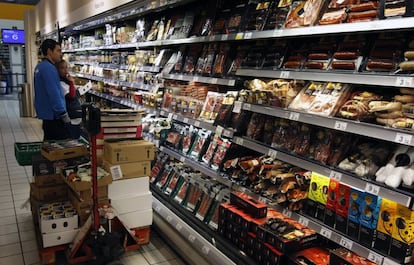 Un empleado repone estanter&iacute;as en un hipermercado.