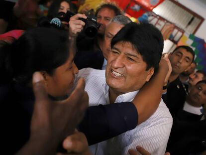 El expresidente de Bolivia, Evo Morales, es recibo por una mujer tras su arribo al aeropuerto de Buenos Aires.