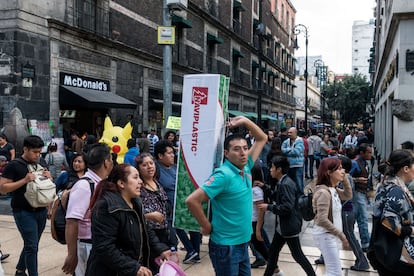 Un hombre carga un árbol de Navidad por una de las calles del centro de Ciudad de México.