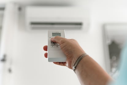 Una mujer regula el aire acondicionado de su casa.