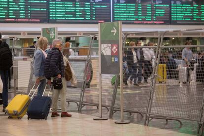 Dos usuarias tratan de entrar en la zona de AVE de la estación de Sants, en Barcelona, que se encuentra vallada en prevención de posibles incidentes.