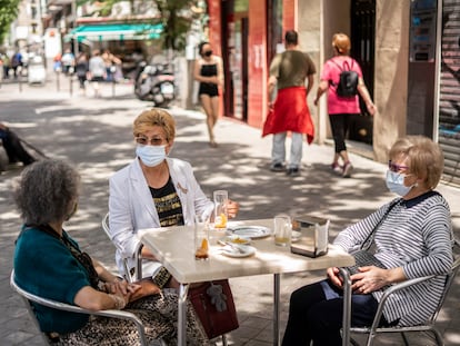 Isabel Cortes, junto a dos amigas, en la terraza de un bar de la calle Antonio López, en el barrio de Usera, Madrid, la semana pasada.