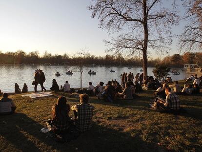 Gente en El Retiro tomando el sol