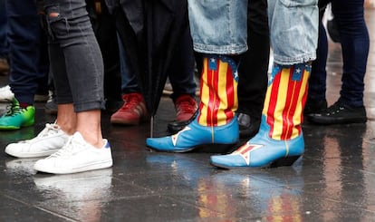 Uma mulher espera para votar com botas com a bandeira independentista estampada em um centro eleitoral de Barcelona.