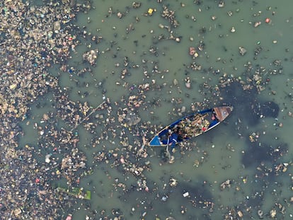 Un hombre limpiando el mar en Yakarta, Indonesia.