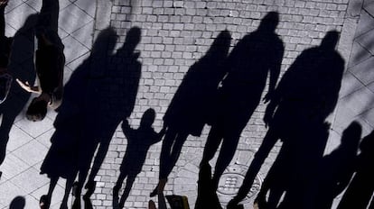 La sombra de un menor y varios adultos en una calle de Sevilla.